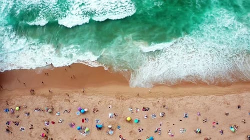 Aerial View of a Vibrant Beach With Sunbathers Enjoying a Sunny Day By the Ocean