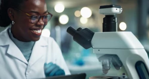 Woman Scientist Using Microscope in Bright Laboratory
