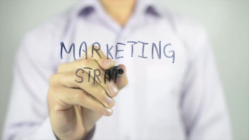 Writing Marketing Strategy on Clear Surface