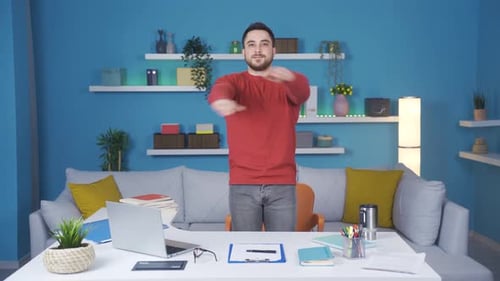 Young businessman showing how to do relaxing exercise in home office. He does standing back and arm
