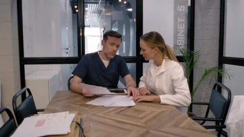 Doctors Discussing Paperwork in Modern Office Setting