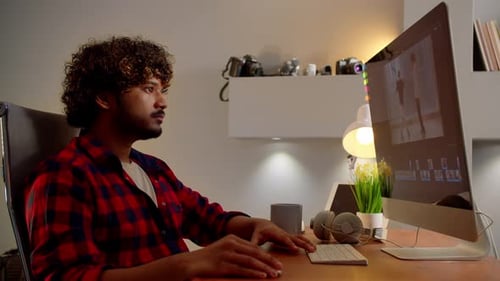 Young Adult Editing Video at Computer Desk