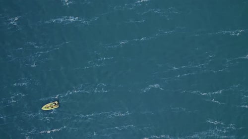 Lonely Motor Boat From Bird's Eye View Floats on Turquoise Water with Light Waves