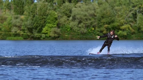 Man Water Skiing Fast on Lake in Summer