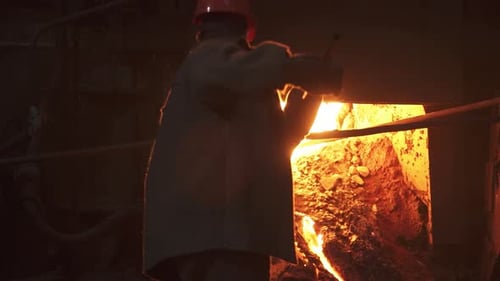 A Worker Skillfully Operates in a Steel Mill Handling Molten Metal Amid Intense Heat Stock Clip