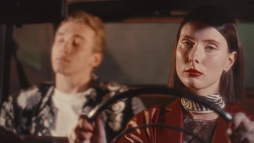 Stylish Young Couple Driving in City at Night