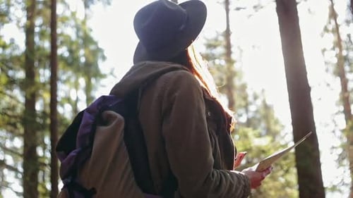 Stylish Traveler Girl in Hat Looking at Map Exploring Woods