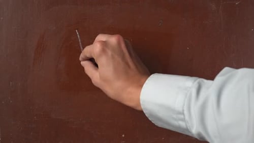 Hand Writes 'Yes' in Chalk on Surface