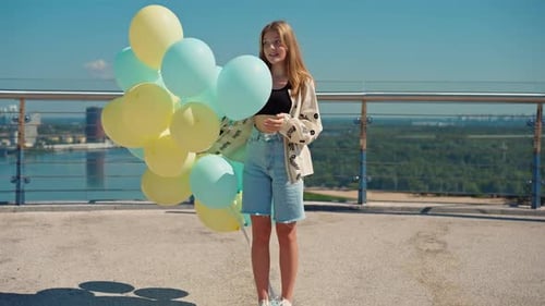 Young Adult with Balloons Overlooking Urban Scene