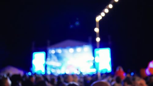 Blurred Crowd Attends Nighttime Outdoor Music Event