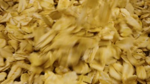 Oatmeal is poured into a terracotta clay bowl. Close-up view.