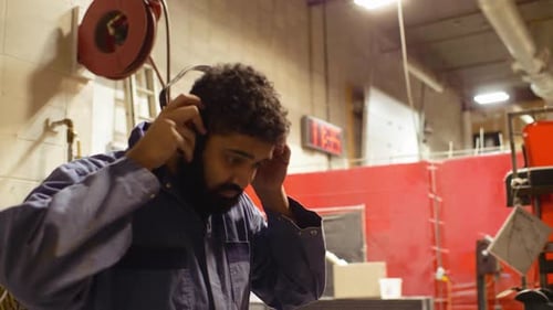 Young african american welder prepares for work in workshop