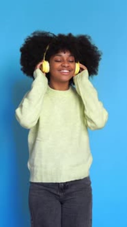 Fröhliche schwarze Frau, die Musik hört