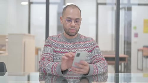 Young Adult Celebrates Good News on Smartphone