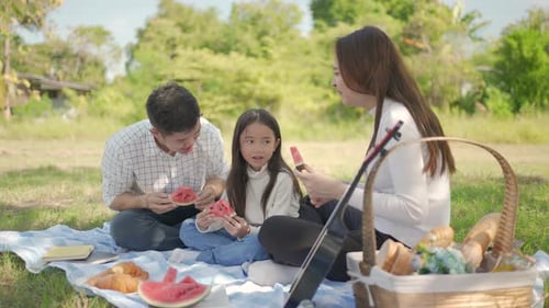Family Eating Watermelon During Picnic in the Countryside