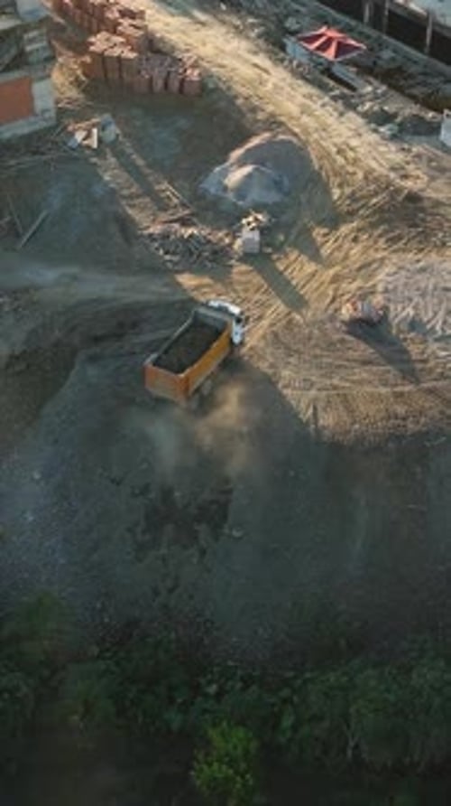 Construction Truck Moving Materials at Building Site