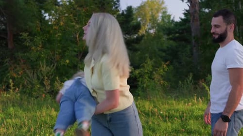 Happy Family Playing Together in a Grassy Field