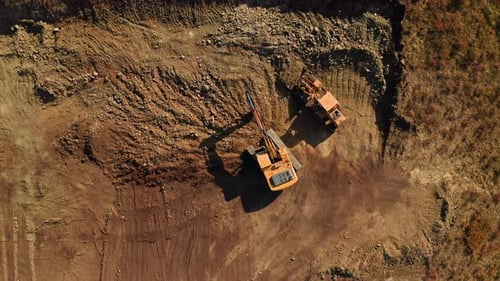 Excavator and Dump Truck Working on Construction Site
