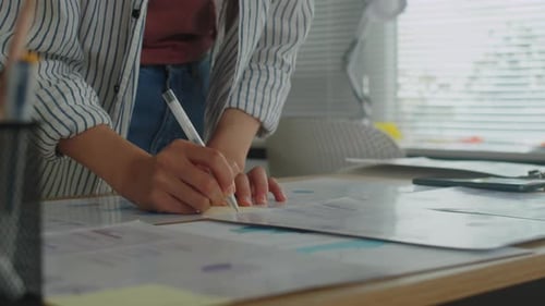 Female Employee Making Notes on Paper Working on Project