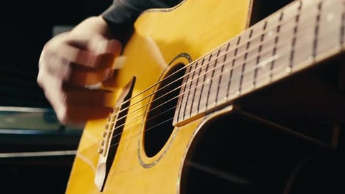 Young Musican Man Checking Strings of Acoustic Guitar Closeup Male Guitarist Tuning Sound of Musical