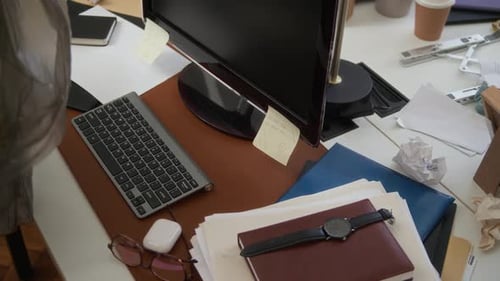 Unerkennbare Reinigungskraft sammelt Müll vom Bürotisch