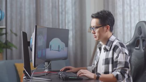 Side View Of Asian Male Automotive Designer Working On 3D Model Of Ev Car On The Desktop Computer