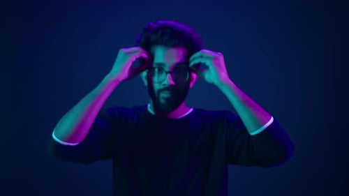 Nahaufnahme eines Mannes, Porträt eines muslimischen Programmierers im Neonstudio, ultravioletter Hintergrund, arabischer Mann, Inder, machen