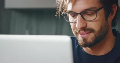Slow motion of young man using a laptop to send work emails, shop online to navigate on social net