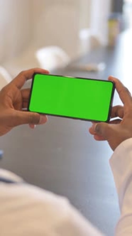 vertical video of Close up of African Man Holding Phone Horizontal with Green Screen