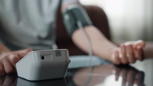 Männliche Hand mit automatischem Tonometer zur Blutdruckkontrolle