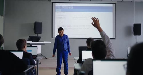 Smart Schoolboy Speaking In Front Classmates In Classroom Presenting Program Code In Class