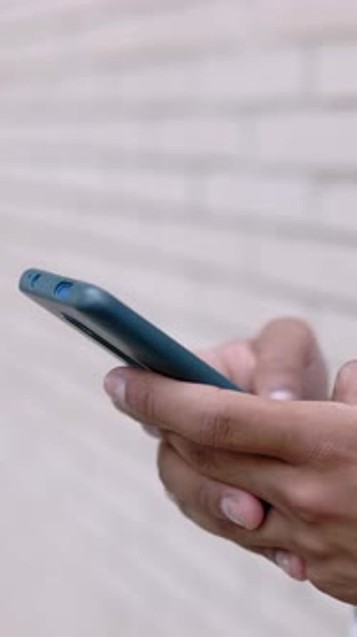 Hands Scrolling a Dark Smartphone in Close Up