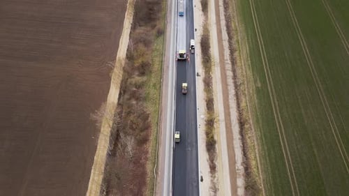 Rollers Level and Compact Asphalt Workers in Helmets Construction of New Road Road Surface Repair