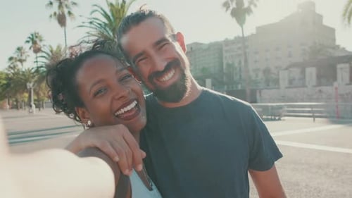 Primer plano de pareja interracial sonriente enamorada haciéndose una selfie