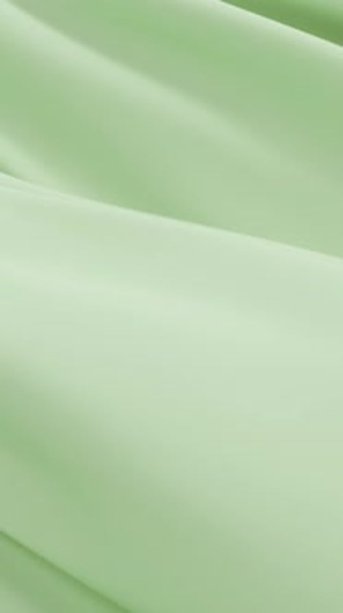Smooth Green Fabric Waving Softly Creating Elegant Minimal Background Gentle Folds Flowing Texture