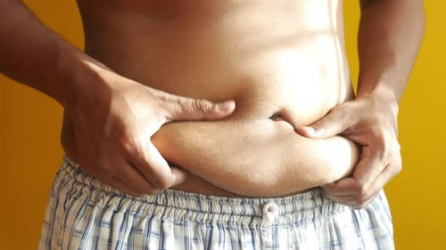 Man's Hand Holding Excessive Belly Fat Overweight Concept