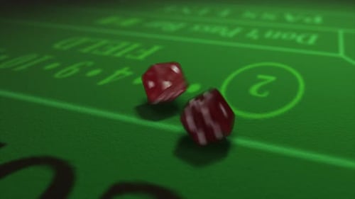 Pair of dice thrown onto a craps or crapaud table with glittering poker machines in a casino backgro