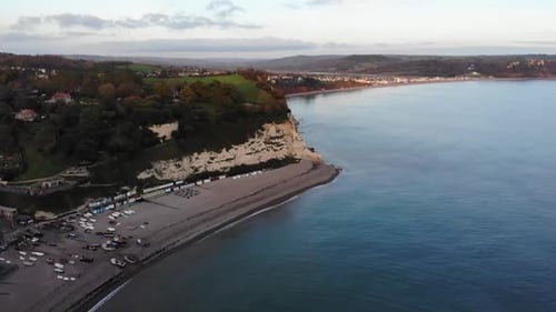 Toma aérea 4K pasando por encima de hermosas playas, barcos y el mar en Beer, Inglaterra, en el Reino Unido