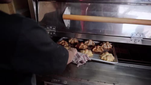 Baker Removes Freshly Baked Bread from Oven