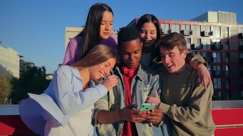 Group of Smiling Friends Looking at Phone Together