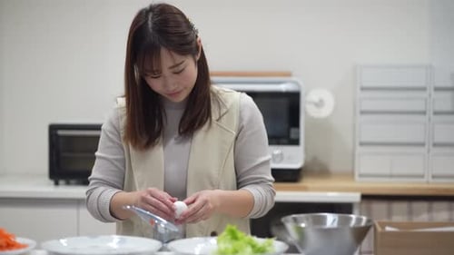 Young Woman Cracking Egg in a Modern Kitchen
