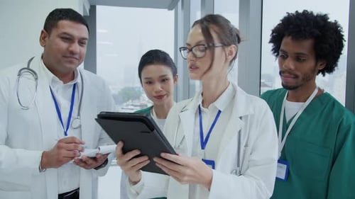 Medical Professionals Reviewing Tablet in Hospital