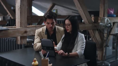 Man and Woman Working Together on a Tablet