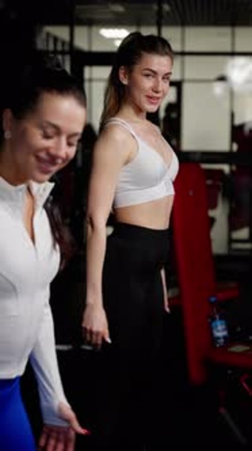 Portrait of Cheerful Athletic Woman in Sports Attire at the Gym Standing with Hand on Hip and a