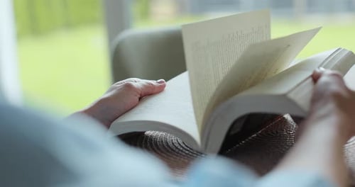 Adult Reading a Book Inside During Daytime