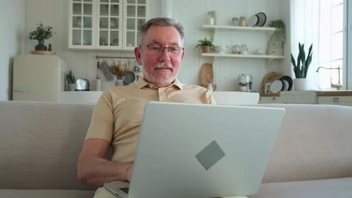 Man Using Laptop Computer at Home on Couch