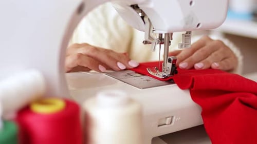 Woman Sewing Red Fabric with Sewing Machine