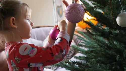 Child Decorates Christmas Tree at Home