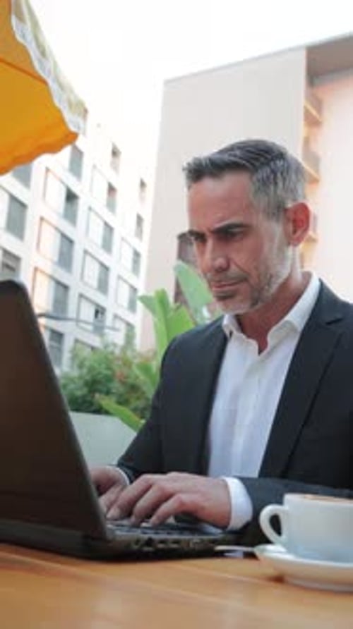 Vertical Mature Business Man Working with a Laptop Outside Sitting at Coffee Shop Handsome Executive
