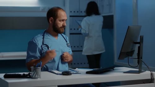 Doctor Completes Paperwork at Desk During Night Shift
